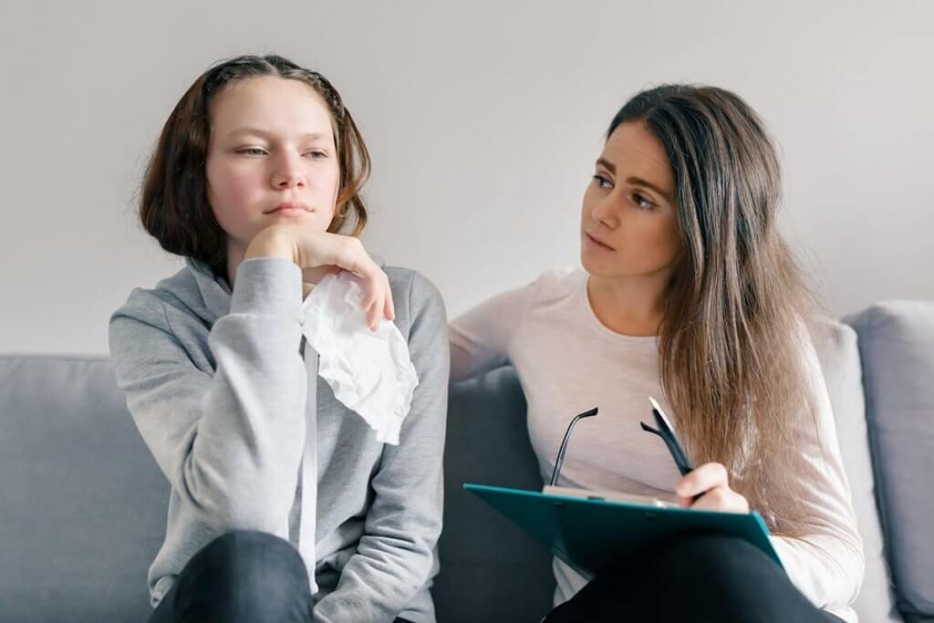 Therapist explains what is cognitive behavioral therapy to a young patient