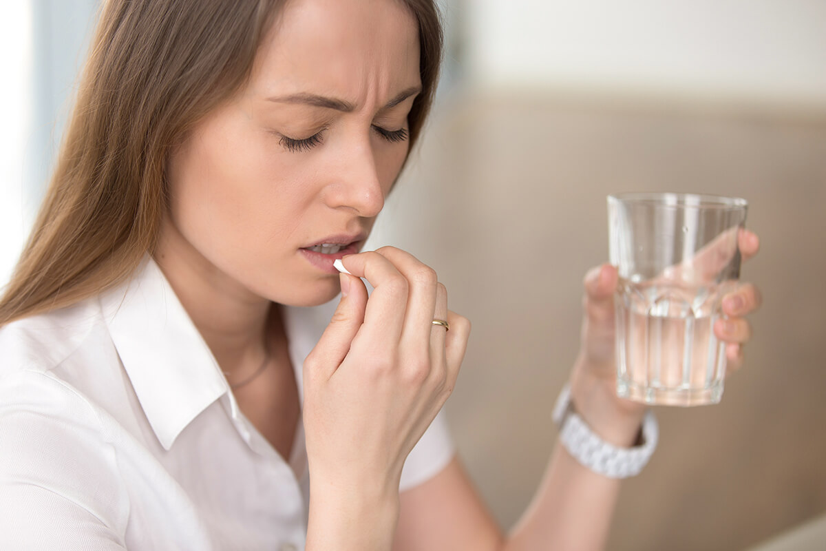 Woman taking a pill of one of the most commonly abused prescription drugs