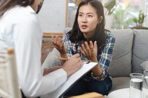 asian female talks to female therapist about an experiential therapy progam