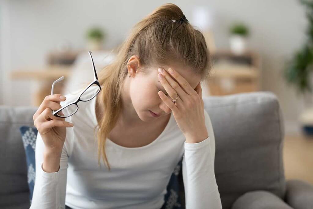signs of benzo withdrawal, woman with hand to forehead, glasses in hand