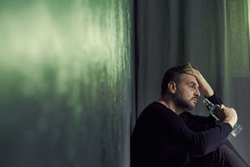 man sitting down drinking thinking what is alcoholic dementia