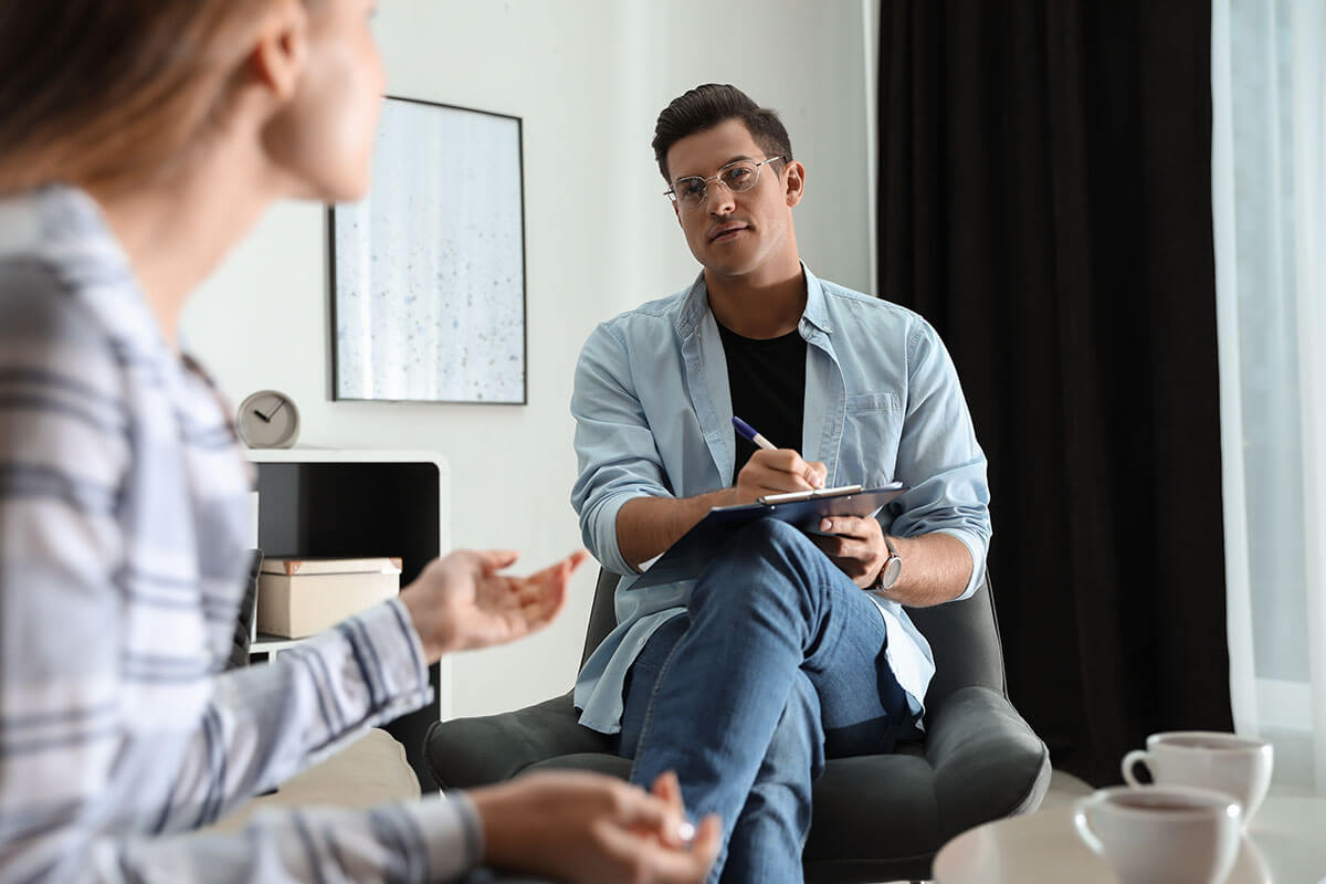 woman talking to male therapist discussing CBT vs DBT