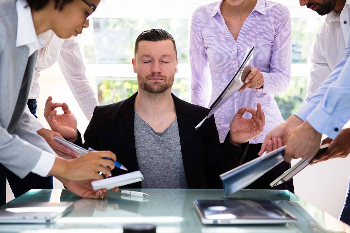 a man being overworked trying to practice stress management techniques