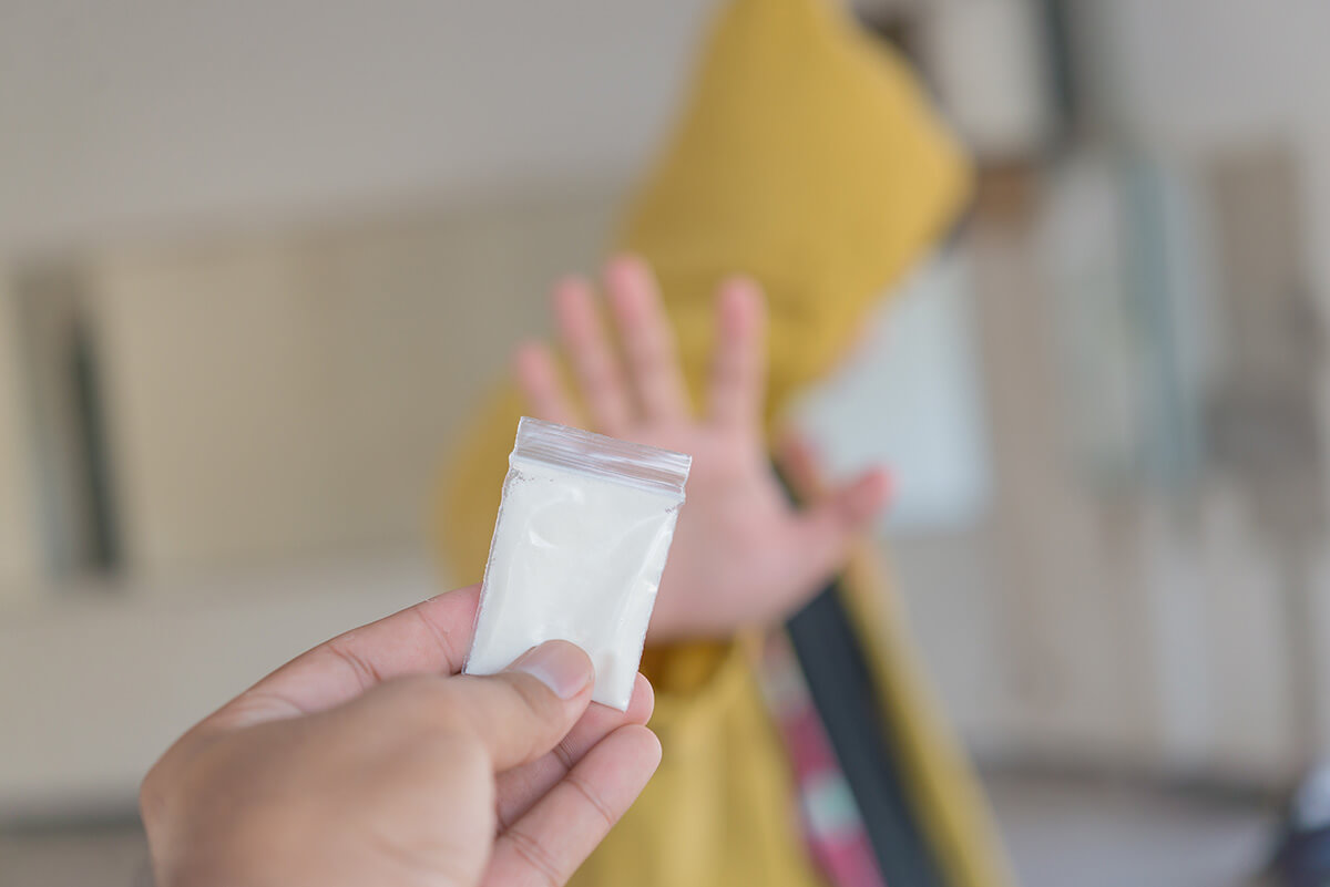 person holding up heroin to another showing What Is the Heroin Epidemic