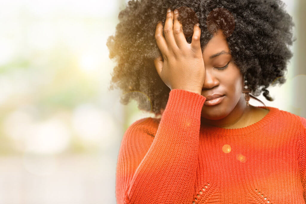 woman rubbing her face recognizing the signs of addiction